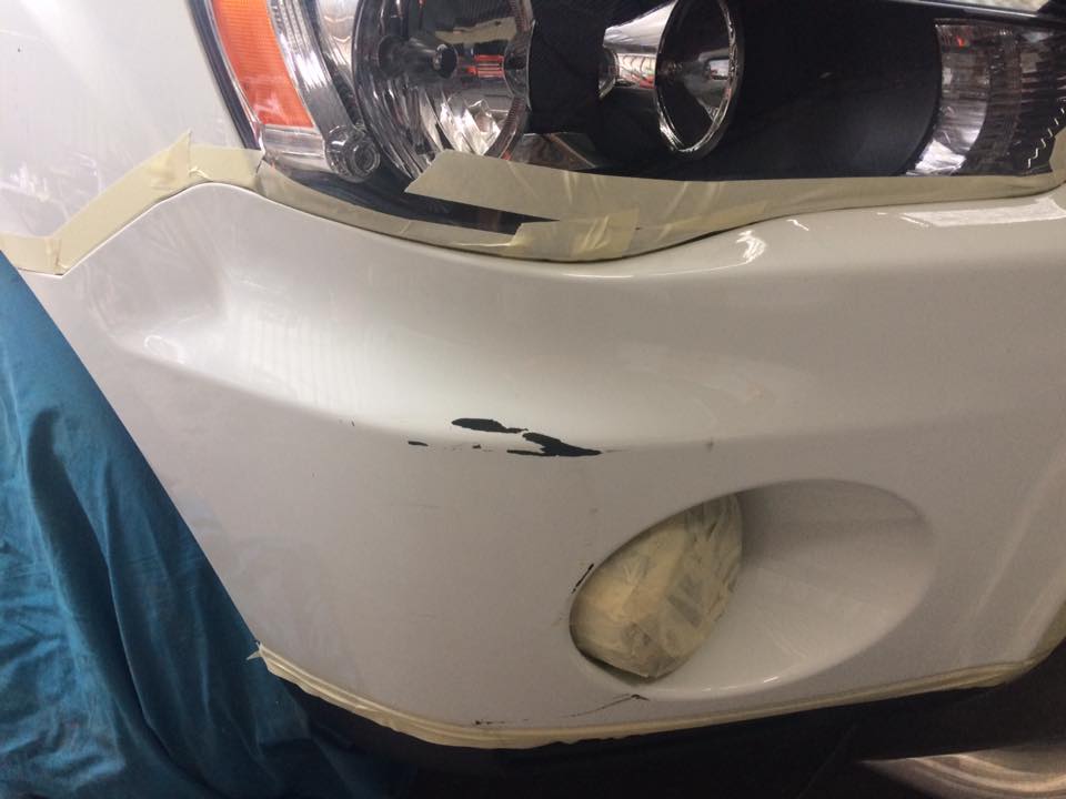 Front bumper and fog light surround, white SUV: Paint chipped back to black plastic, taped off ready to go.