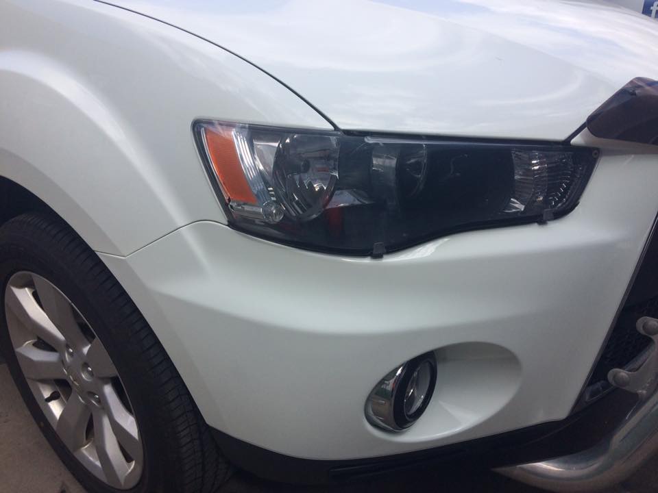 Front bumper and fog light surround, white SUV: Chips filled and blended, pearl white matched right through.