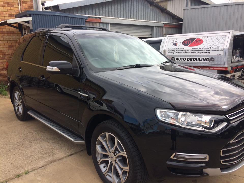 A black Ford Territory polished to a mirror finish outside the Red Bac workshop in Bundaberg East