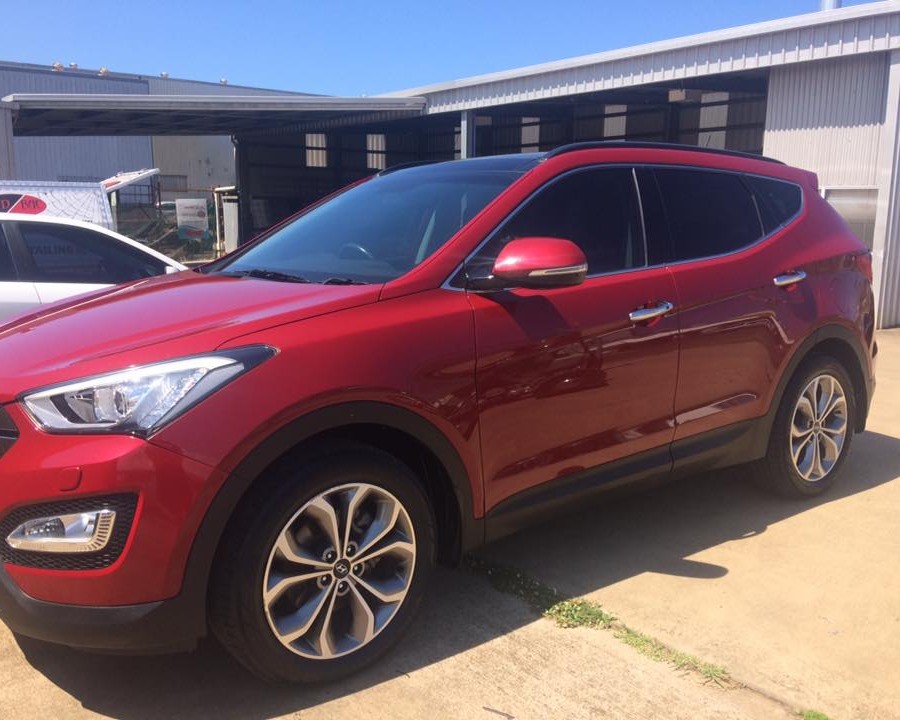 A red Hyundai Santa Fe polished and parked at the Bundaberg East workshop